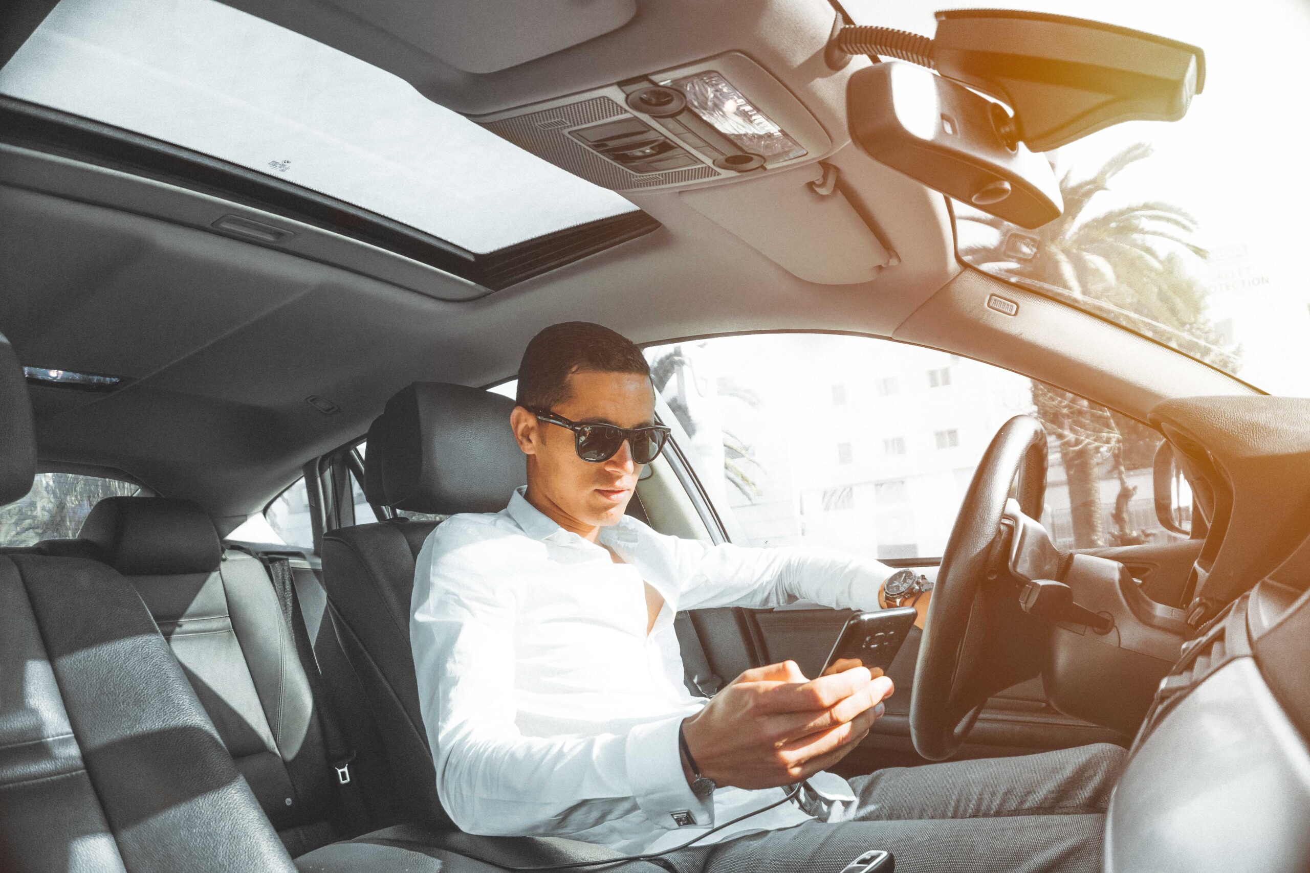 Man in white dress shirt holding smartphone